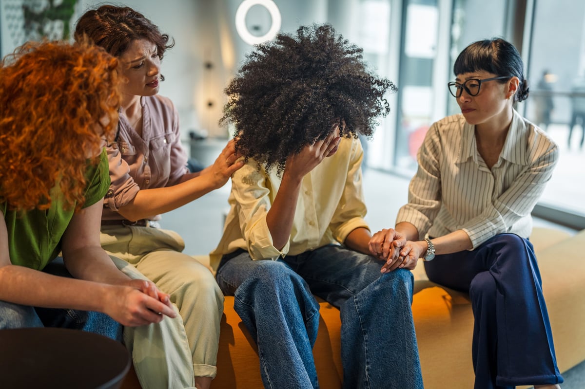 Women offering comfort and holding hands during a supportive conversation